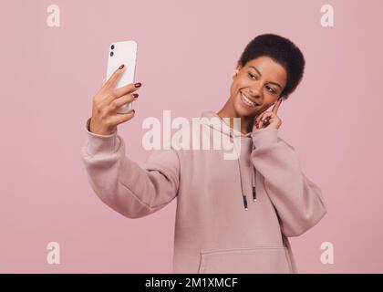 Belle fille noire souriante filmant selfie sur l'appareil photo avant. Portrait en gros plan d'une femme afro-américaine joyeuse ayant la vidéo-appel Banque D'Images