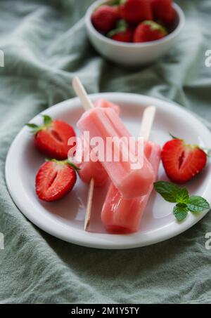 Glaces aux fraises surgelées faites maison et fraises fraîches sur fond de béton. Dessert d'été Banque D'Images