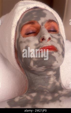 Gros plan d'une femme qui a un visage. Visage et cou peints, avec un papier essuie-tout Banque D'Images