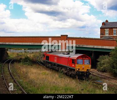 LA locomotive diesel DB Cargo 66009 passe sous le pont de Ash Street sur la ligne Southport jusqu’à Wigan, passant par l’ancien site de la station St Luke. Banque D'Images