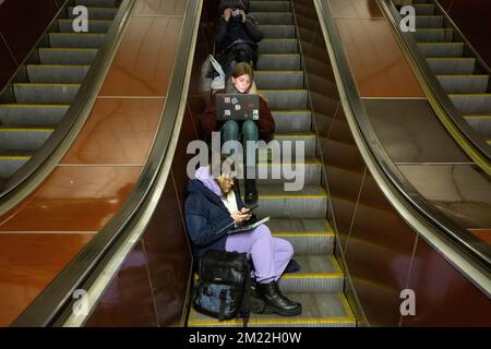 Kiev, Ukraine. 13th décembre 2022. Les personnes avec des tablettes et des ordinateurs portables travaillent à l'intérieur d'une station de métro pendant une alerte RAID aérien dans le centre de Kiev. Les civils utilisent les stations de métro de Kiev comme abri lors de raids aériens. (Credit image: © Oleksii Chumachenko/SOPA Images via ZUMA Press Wire) Banque D'Images