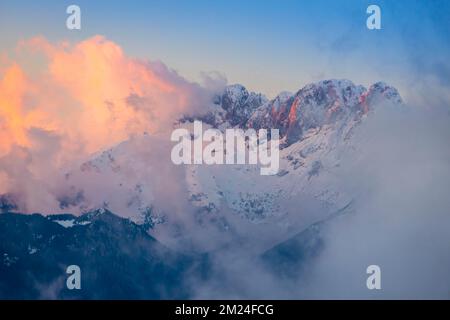 Vue sur la montagne Presolana entre les nuages sur un coucher de soleil d'hiver. Val Seriana, Castione della Presolana, Bergame district, Lombardie, Italie. Banque D'Images