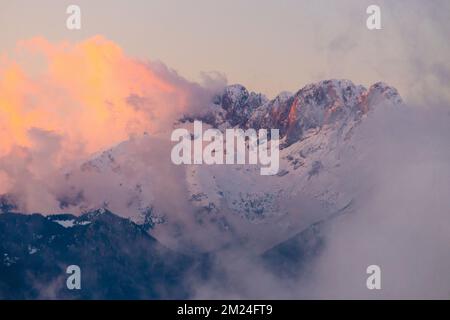 Vue sur la montagne Presolana entre les nuages sur un coucher de soleil d'hiver. Val Seriana, Castione della Presolana, Bergame district, Lombardie, Italie. Banque D'Images