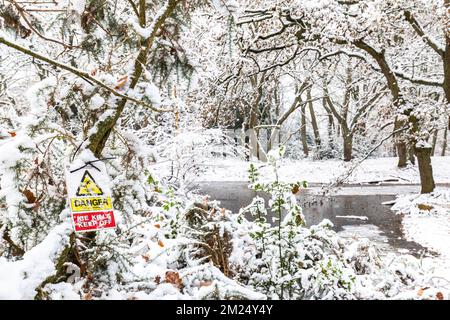 Hampstead Heath a un certain nombre d'étangs qui pose un danger de noyade.clair jaune et rouge signes d'avertissement de mort, photographiés par l'un des étangs de congélation Banque D'Images