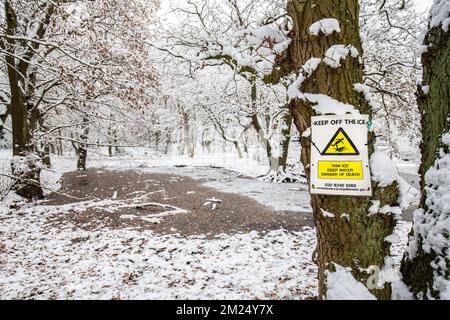 Hampstead Heath a un certain nombre d'étangs qui pose un danger de noyade.clair jaune et rouge signes d'avertissement de mort, photographiés par l'un des étangs de congélation Banque D'Images