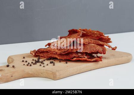 Certaines boîtes en carton de spécialité avec des friandises déshydratées pour chiens, la plus haute est ouverte, pleine de viande sèche croquante goûts de boeuf et de poulet. Animal de compagnie fait maison Banque D'Images