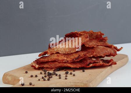 Certaines boîtes en carton de spécialité avec des friandises déshydratées pour chiens, la plus haute est ouverte, pleine de viande sèche croquante goûts de boeuf et de poulet. Animal de compagnie fait maison Banque D'Images