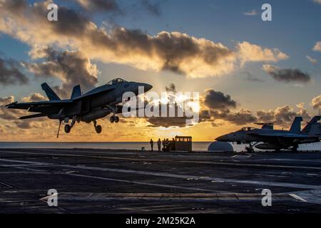 San Diego, États-Unis. 07 décembre 2022. ÉTATS-UNIS L'avion de chasse Super Hornet F/A-18E de la Marine, avec les vigilantes du Strike Fighter Squadron 151, approche pour atterrir au coucher du soleil sur le pont de vol du porte-avions de la classe Nimitz USS Abraham Lincoln, 7 décembre 2022 à San Diego, Californie. Crédit : MCS Julia Brockman/Planetpix/Alamy Live News Banque D'Images