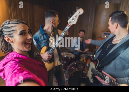 groupe de musique ayant une répétition et un chanteur prenant un selfie dans le studio d'enregistrement. Photo de haute qualité Banque D'Images