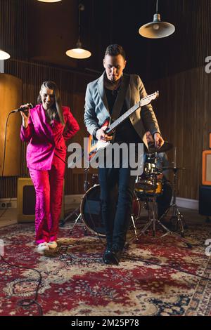 plan vertical d'un groupe musical de jeunes, d'une chanteuse, d'un guitariste et d'un batteur. Photo de haute qualité Banque D'Images