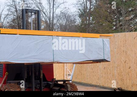 Les matériaux de construction sont déchargés à l'aide d'un chariot élévateur sur le chantier Banque D'Images