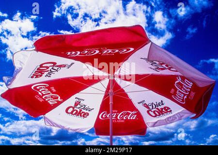 Un parapluie au coca cola rouge et blanc lumineux dans un café en bord de mer sur la côte du Maine Banque D'Images