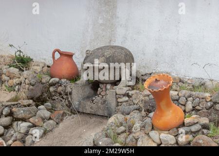 Une petite sculpture de grenouille en béton dans un mouillage sec avec deux pots en céramique rouge au milieu de la ville Banque D'Images