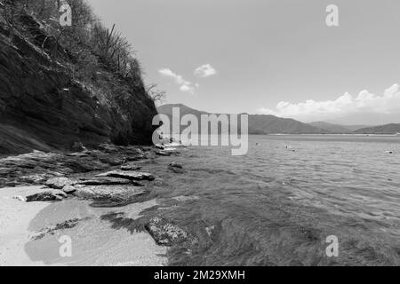 Belle photographie en noir et blanc du parc naturel colombien Tayrona avec montagne rocheuse et baie de concha en arrière-plan Banque D'Images