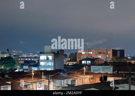 Bogota Nord quartier industriel ville de nuit se éclaire avec la ville de la calera lumière en arrière-plan dans ciel nuageux de nuit. Banque D'Images