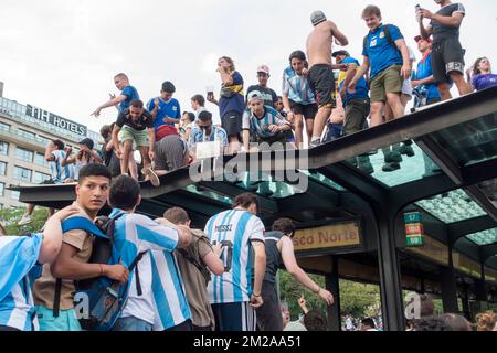 Les fans argentins grimpent au sommet de l'abri de bus sur l'avenue du 9th juillet, Buenos Aires, Argentine pour célébrer l'équipe nationale qui a atteint la finale de 2022 Banque D'Images