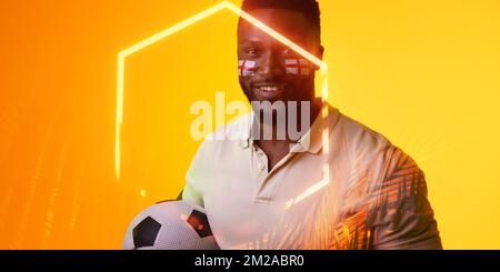 Hexagone illuminé sur un fan mâle afro-américain avec ballon de football et peinture du visage du drapeau de l'angleterre Banque D'Images