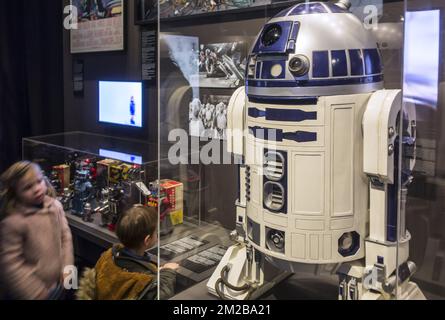 Curieux enfants regardant le robot R2-D2, série R2 astromech droid dans les films Star Wars | enfants régents D2-R2 / R2-D2, robot de la saga cinématographique Star Wars 26/11/2017 Banque D'Images