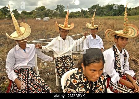 Les élèves portant la tenue traditionnelle de l'île de Rote sont photographiés lors d'un événement cérémonial pour libérer les tortues endémiques à col serpent (Chelodina mccordi) dans son habitat convenable à l'île de Rote, à l'est de Nusa Tenggara, en Indonésie. La conservation communautaire est promue comme stratégie d'amélioration de la gestion des ressources par l'engagement communautaire, tandis que les approches traditionnelles de gestion reposent sur les lois et pratiques coutumières pour réglementer l'utilisation des ressources naturelles. Banque D'Images