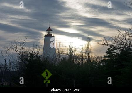 Sandy Hook Lighthouse silhouette contre un ciel principalement nuageux au coucher du soleil -79 Banque D'Images