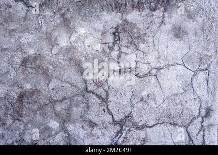 Mur en béton fissuré recouvert d'une texture de ciment gris comme arrière-plan. Banque D'Images