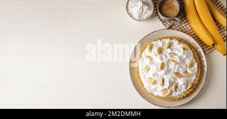 Assiette avec gâteau savoureux à la banane sur fond de bois blanc avec espace pour le texte Banque D'Images