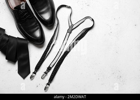 Chaussures, bretelles et cravates en cuir sur fond léger Banque D'Images