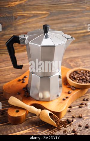 Planche à repasser avec cafetière geyser, pelle et assiette de haricots sur fond de bois Banque D'Images