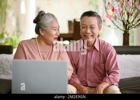 Joyeux couple senior souriant qui appelle les membres de sa famille sur le nouvel an lunaire Banque D'Images