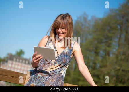 Jeune femme avec une tablette. | Femme avec une nappe. 05/05/2016 Banque D'Images