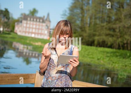 Jeune femme avec une tablette. | Femme avec une nappe. 05/05/2016 Banque D'Images