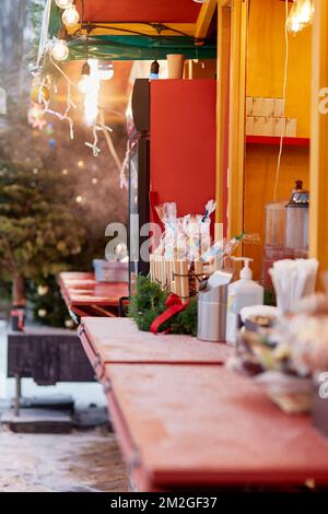 Sucettes sucrées au marché de Noël avec décorations et lumières le jour de neige. Joyeux Noël et joyeuses fêtes. Banque D'Images