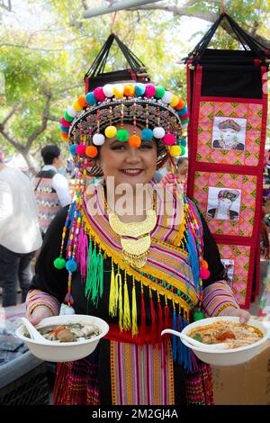 Une femme en tenue traditionnelle tenant deux bols de soupe Hmong au Hmong New Year Celebration au parc El Dorado à long Beach, CA Banque D'Images