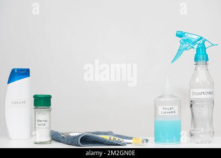 Produits de nettoyage pour la maison avec étiquettes dans des bouteilles en plastique réutilisées. Récipients ménagers recyclés sur fond blanc. Espace de copie horizontal. Réduire le concept. Banque D'Images