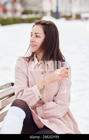 Une femme fête ses vacances avec un verre de champagne à l'extérieur. Bonne Saint Sylvestre. Banque D'Images