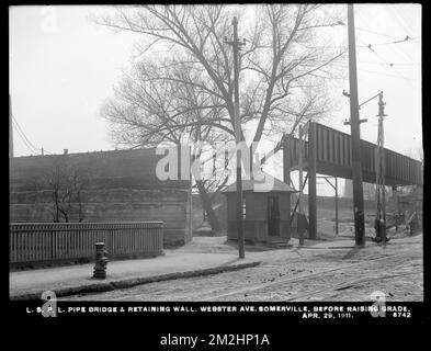 Service de distribution, lignes de tuyauterie à service réduit, pont de tuyauterie et mur de soutènement, Webster Avenue, avant l'élévation de grade, Somerville, Mass., 29 avril 1911 , travaux d'eau, conduites de tuyaux, sites de construction Banque D'Images