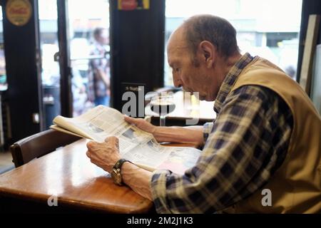 L'illustration montre un homme lisant un journal avec une bière spéciale à table, à marge de la présentation du livre 'Estaminets et cafés: Une histoire bruxelloise' au café le petit Lion, dans le centre-ville de Bruxelles, le mardi 21 août 2018. BELGA PHOTO ERIC LALMAND Banque D'Images