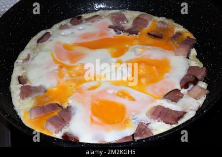 photo des œufs frits avec des morceaux de bacon sur la poêle Banque D'Images