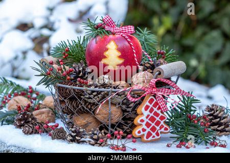 pomme avec décoration d'arbre de noël dans un panier avec des cônes et des noix comme décoration de noël Banque D'Images