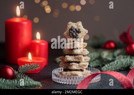 Caviar noir hors-d'œuvre étoiles sur une table noire décorée de noël avec des bougies rouges et bokeh horizontal Banque D'Images