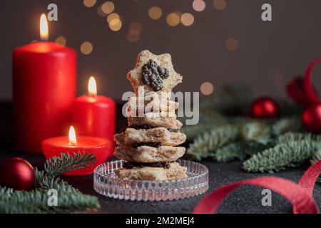 Caviar noir hors-d'œuvre étoiles sur une table noire décorée de noël avec des bougies rouges et bokeh horizontal Banque D'Images