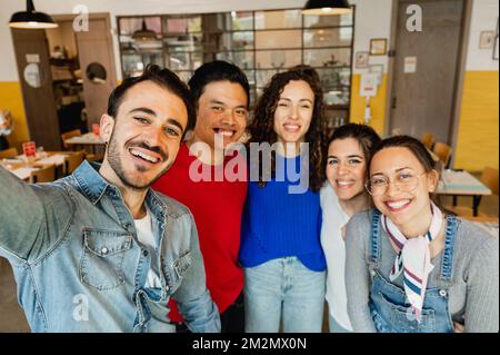 Groupe multiracial de jeunes qui prennent le selfie à l'intérieur Banque D'Images