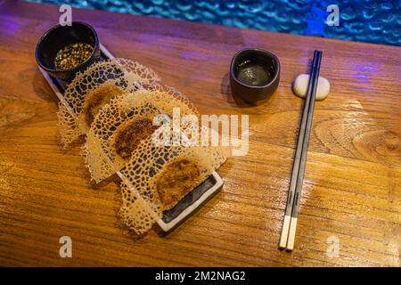 Des boulettes gyoza poêlées sur un fond de bois rustique dans un restaurant de luxe. Cuisine gastronomique exclusive. Cuisine japonaise artistique Banque D'Images