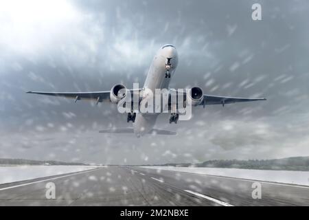 Décollage d'un avion de ligne dans de la neige épaisse et un blizzard à l'aéroport de départ. Le concept de mauvais temps, les retards de vol et les annulations Banque D'Images