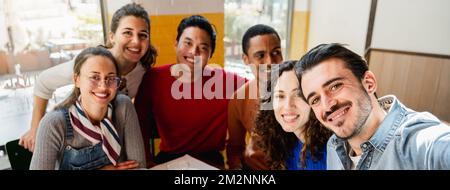 Bannière horizontale ou en-tête groupe multiethnique de six amis Prenez une photo de selfie dans un restaurant à la table tout en mangeant de la pizza. Les gens avec bonne gaif Banque D'Images