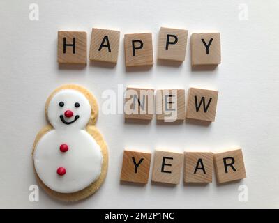Biscuit bonhomme de neige au pain d'épice et bonne année en 3D lettres en bois de l'alphabet isolées sur un fond blanc Banque D'Images