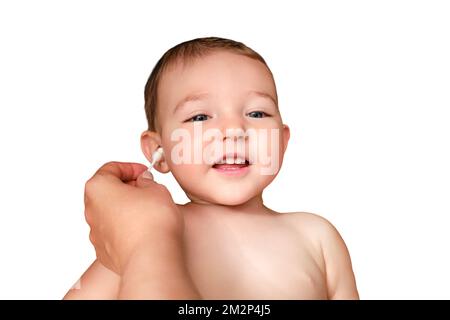 La mère nettoie l'oreille avec un coton-tige pour le bébé garçon heureux, isolé sur un fond blanc. Maman nettoie les oreilles d'un enfant souriant, est Banque D'Images