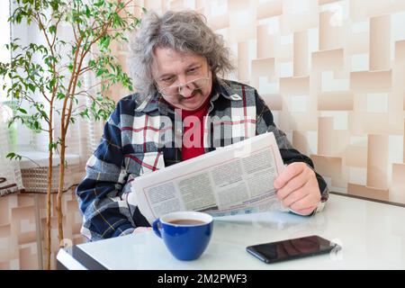Portrait d'un homme âgé lisant un journal Banque D'Images
