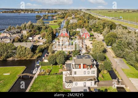 une vue aérienne de quelques maisons dans la région du pays avec un plan d'eau et des arbres des deux côtés Banque D'Images