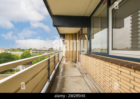 balcon avec ciel bleu et nuages blancs en arrière-plan, vu de la fenêtre avant d'un appartement Banque D'Images